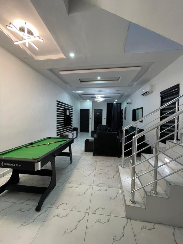 Modern luxury living room with high-end furniture and snooker board in a Lagos shortlet apartment.